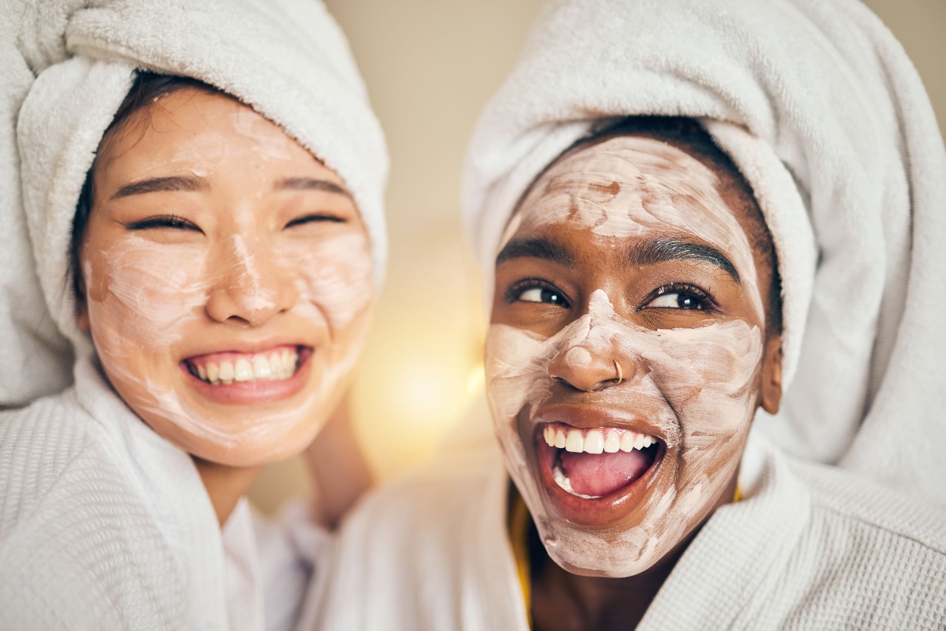 Two women with towels wrapped around their heads and face masks on their faces.