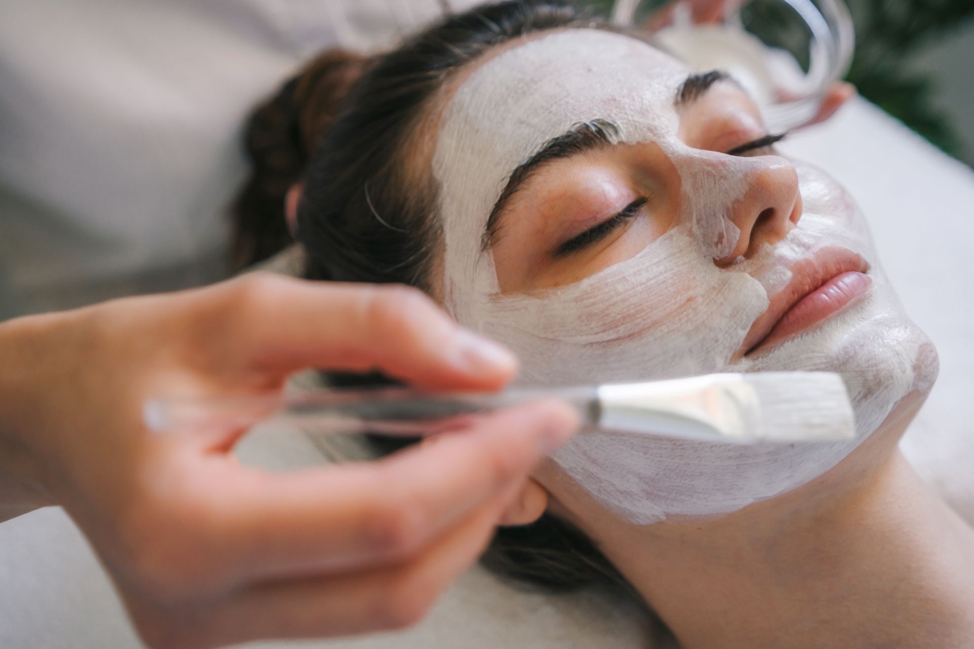 A woman is getting a facial treatment at a spa.