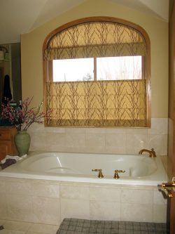 A bathroom with a jacuzzi tub and a window with shades