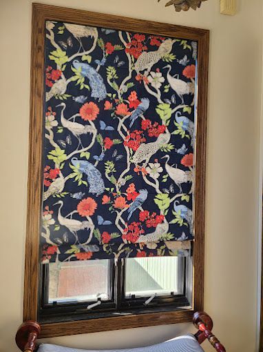 A window with a floral pattern on it and a wooden frame.