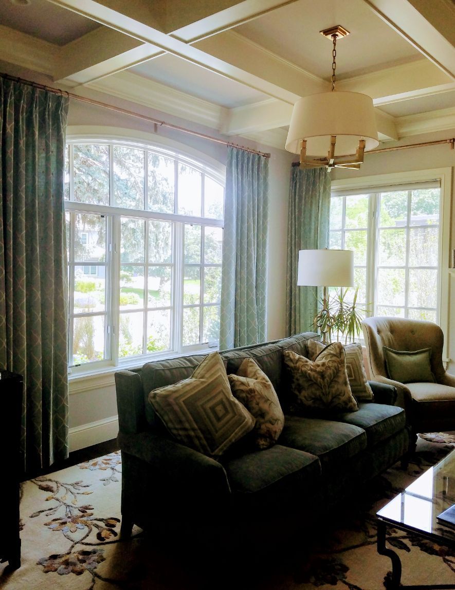 A living room with a couch and printed window curtains
