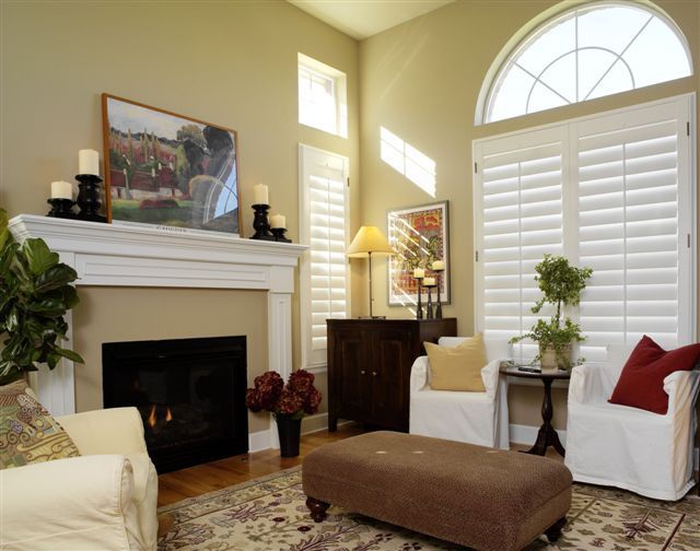 A living room with a fireplace and white shutters