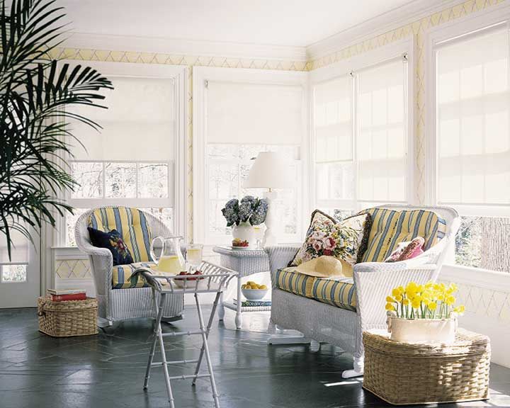 A living room with a couch , chairs, table and white window shades