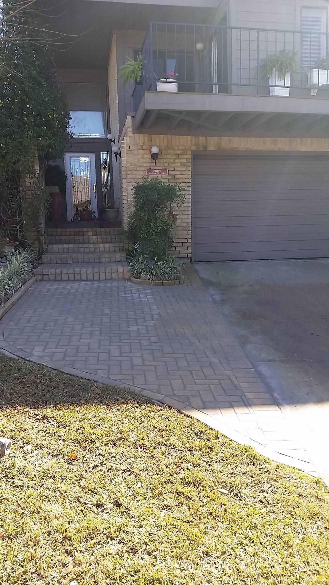 The front of a house with a garage and a balcony.