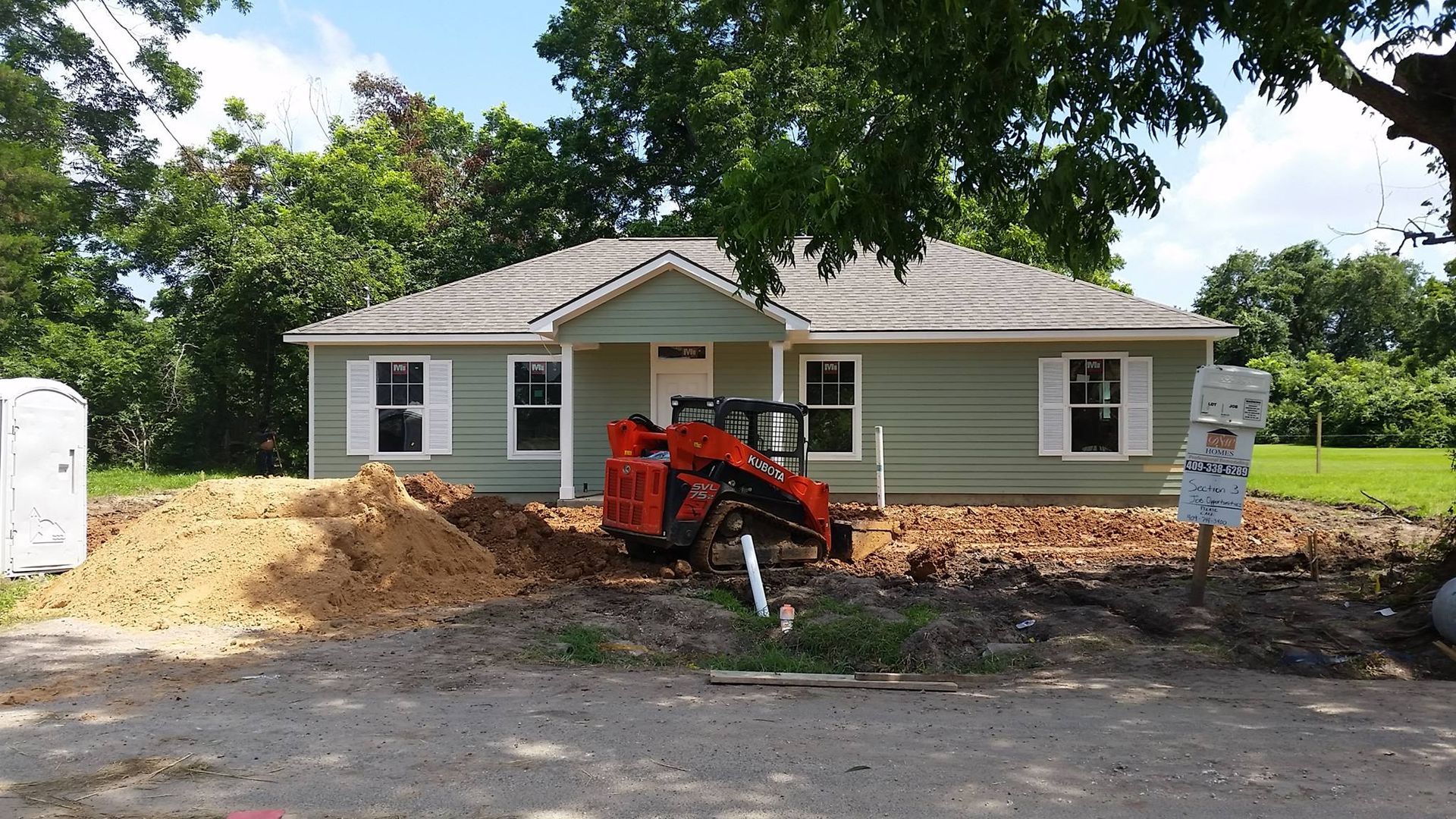 A house under construction with a tractor in front of it