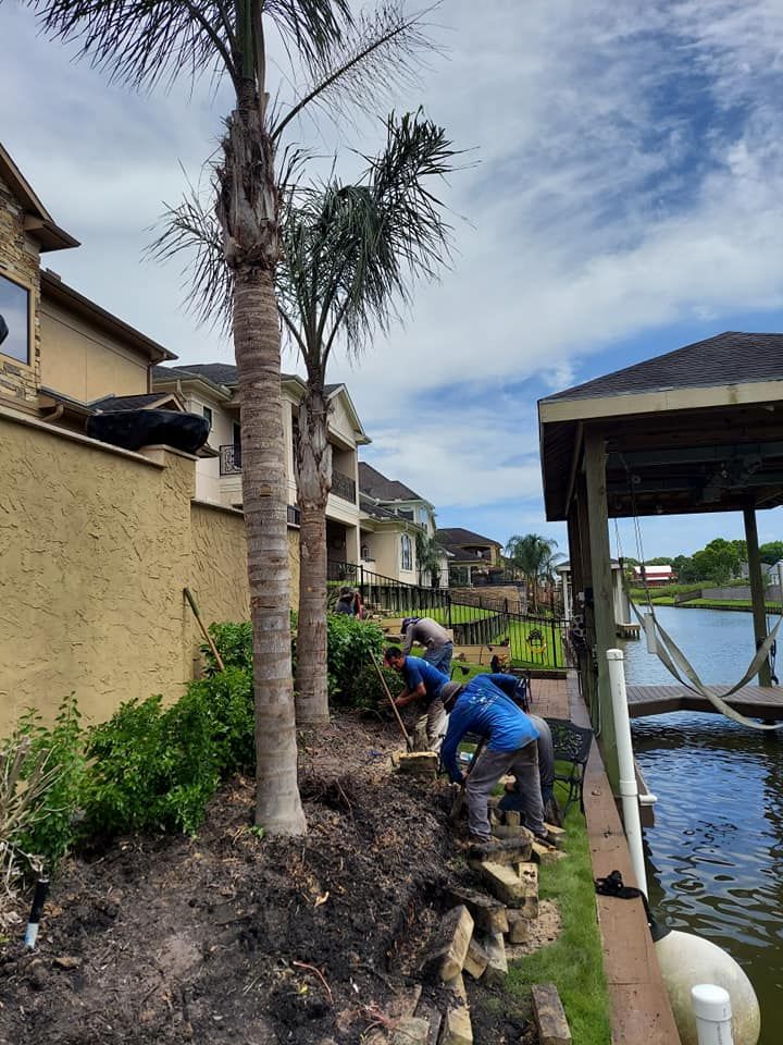 A group of people are working on a fence next to a body of water.