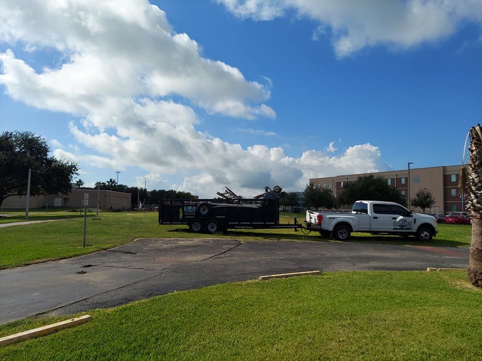 A white truck with a trailer attached to it is parked in a parking lot.