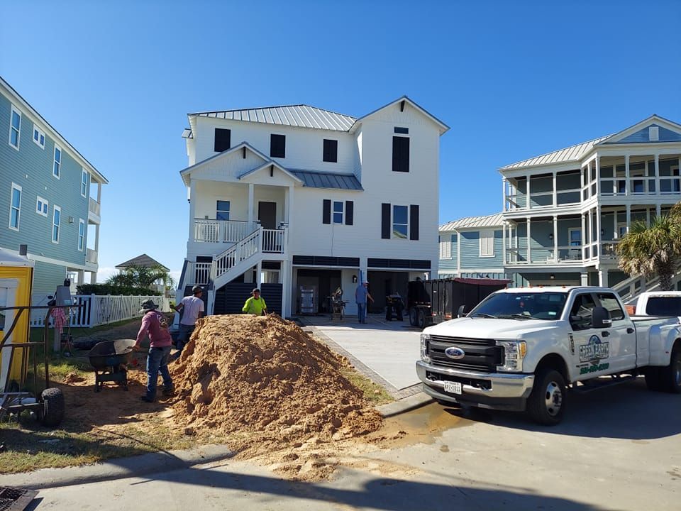 A white truck is parked in front of a large white house.