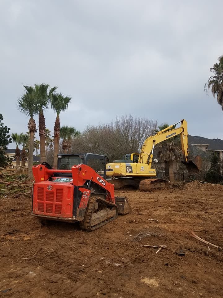 A bulldozer and an excavator are sitting in a dirt field.