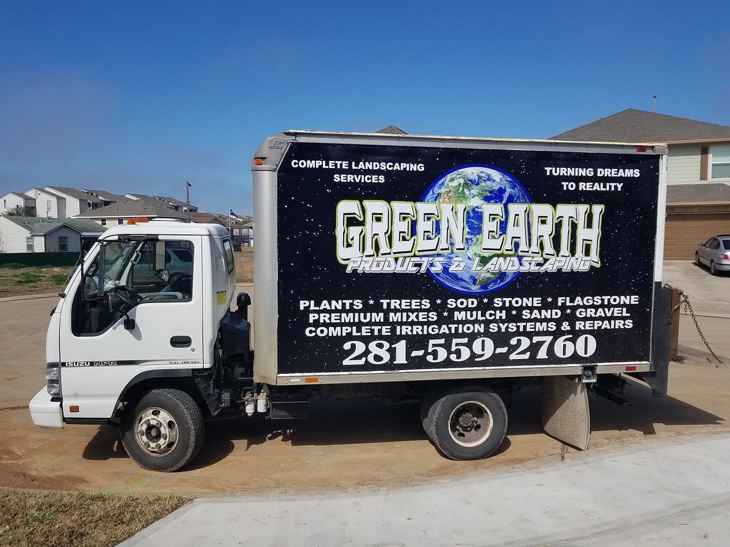A green earth truck is parked on the side of the road