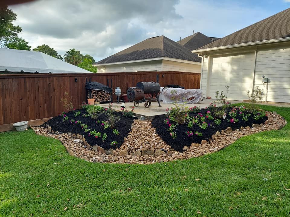 A backyard with a fence , flowers , and a grill.