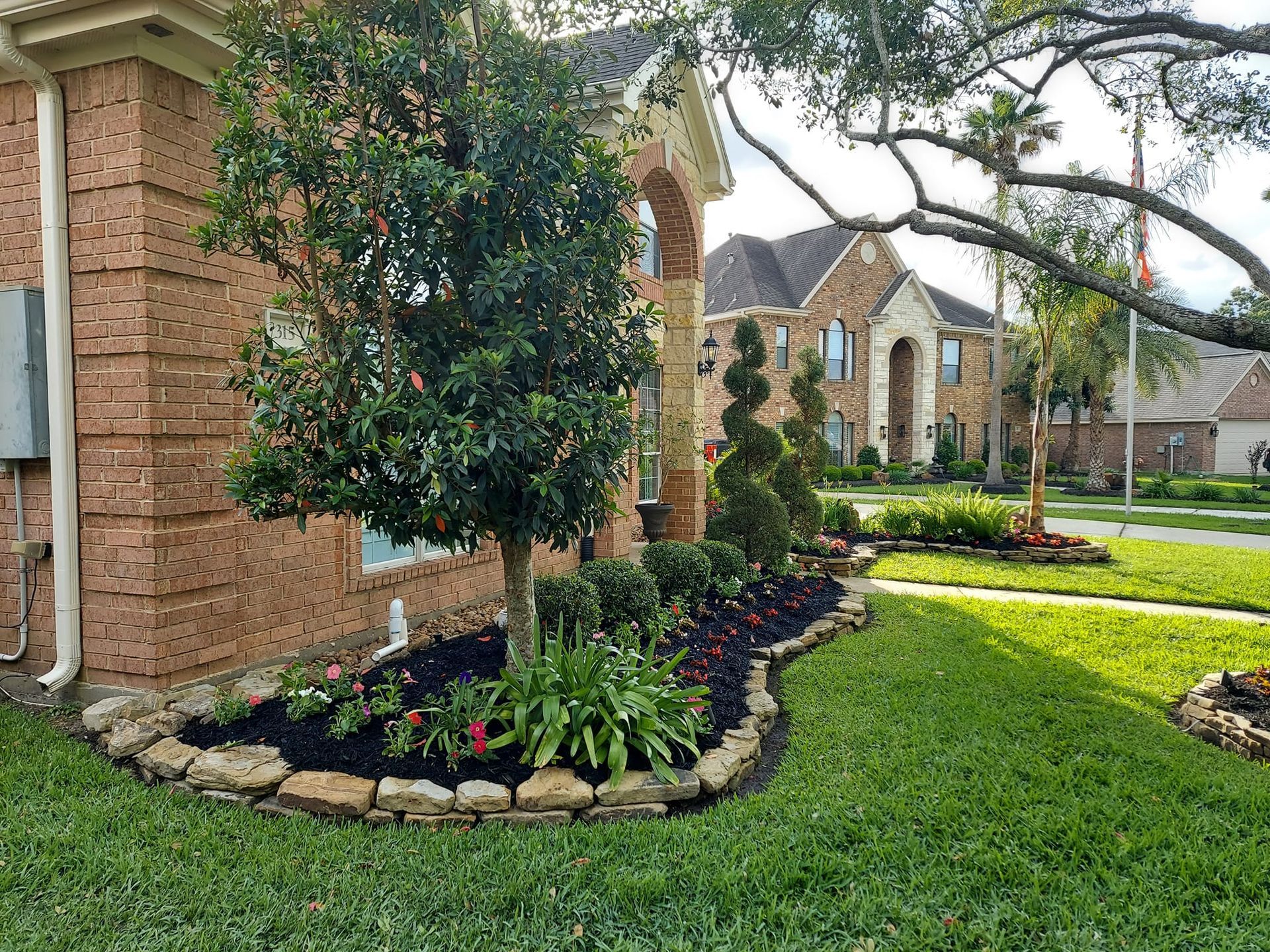 A brick house with a lush green lawn in front of it.