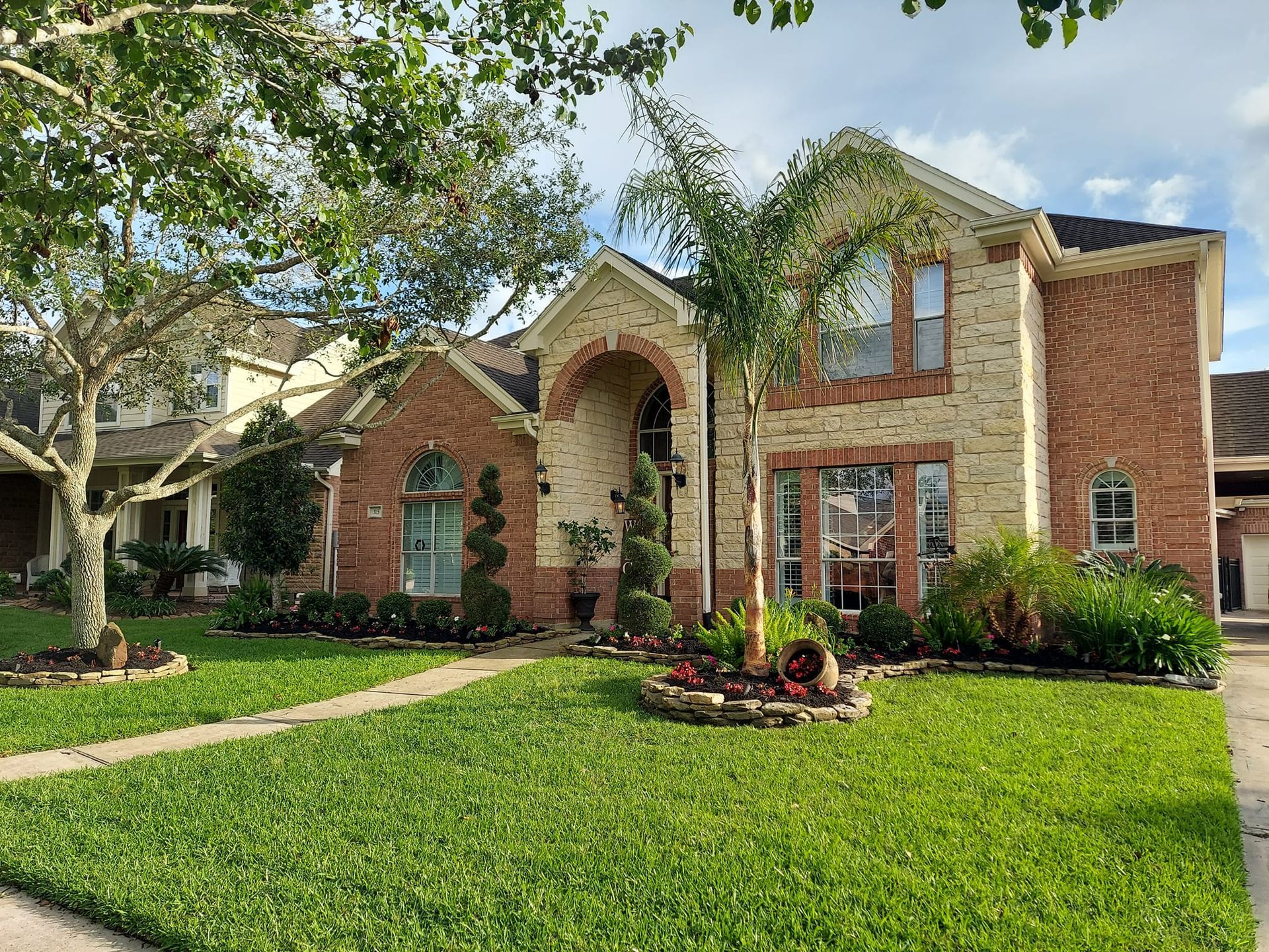 A large brick house with a lush green lawn in front of it.