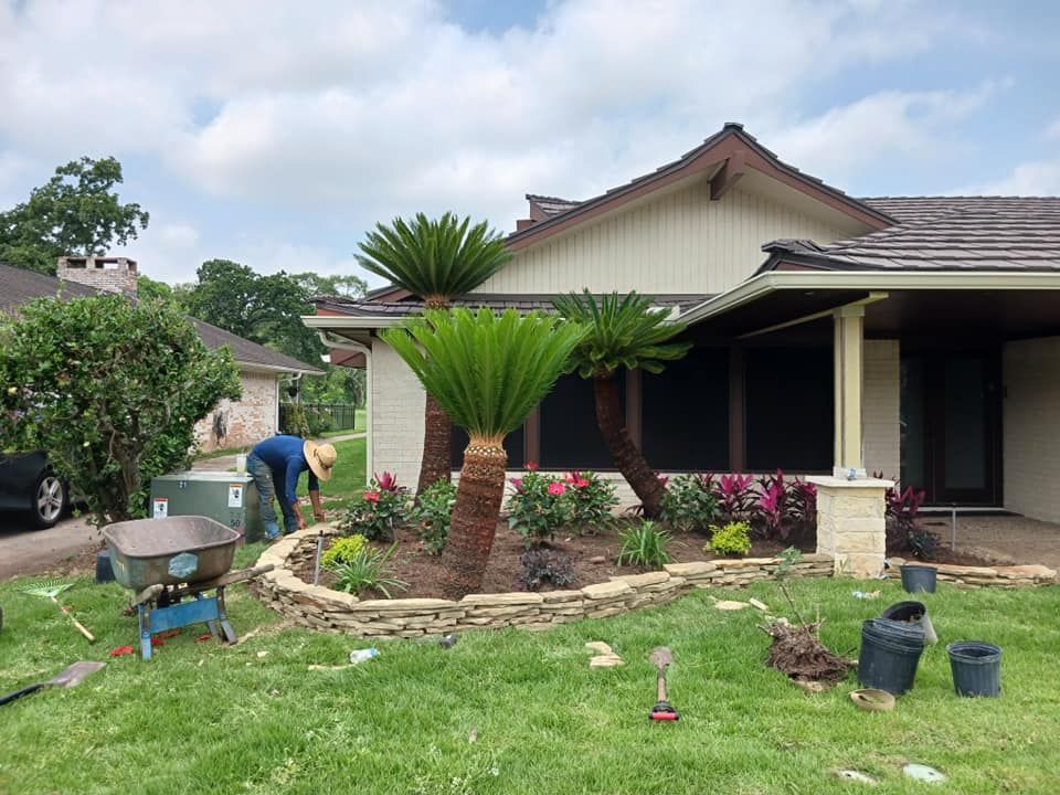 A man is working on a garden in front of a house.