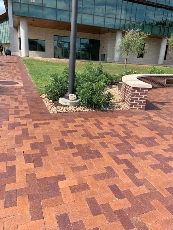 A brick walkway in front of a large building