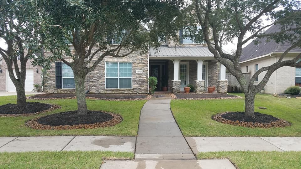 A house with a walkway leading to it and trees in front of it
