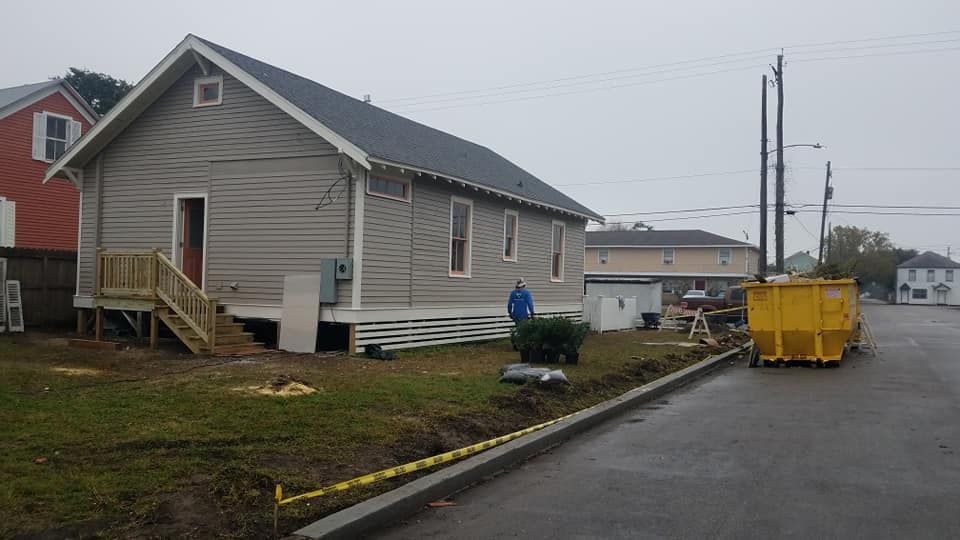 A small house is being built on stilts on the side of the road.