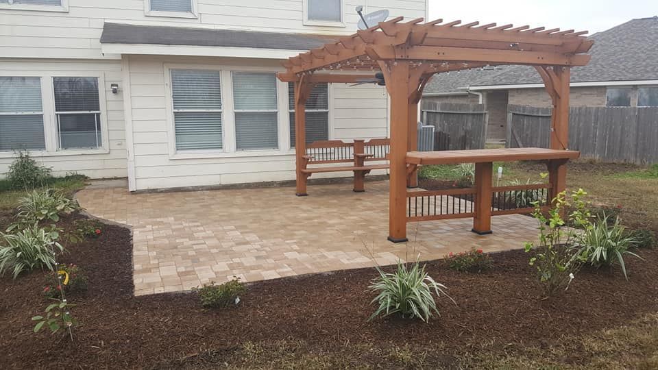 A wooden pergola is in the backyard of a house.
