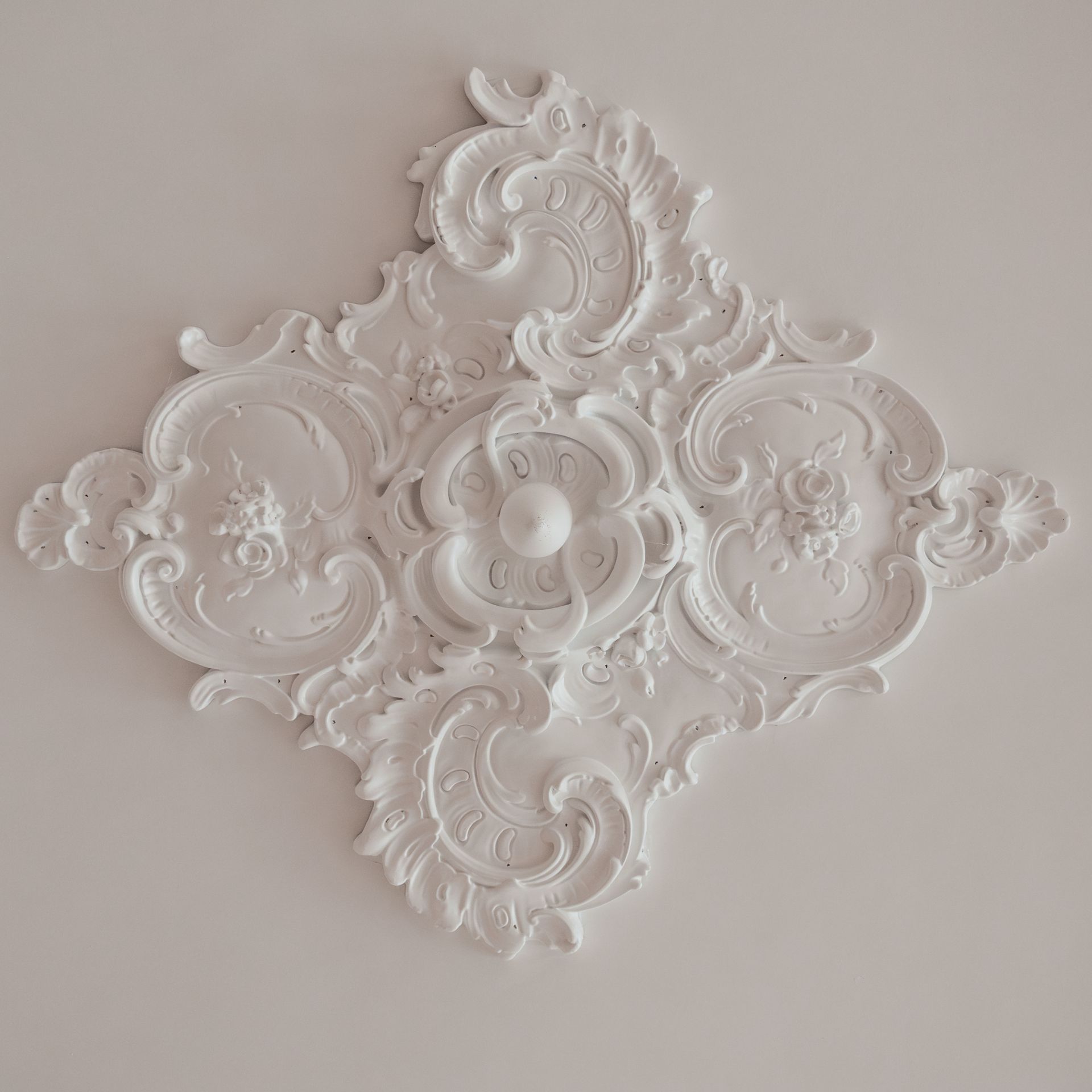 A close-up of a decorative ceiling medallion is white