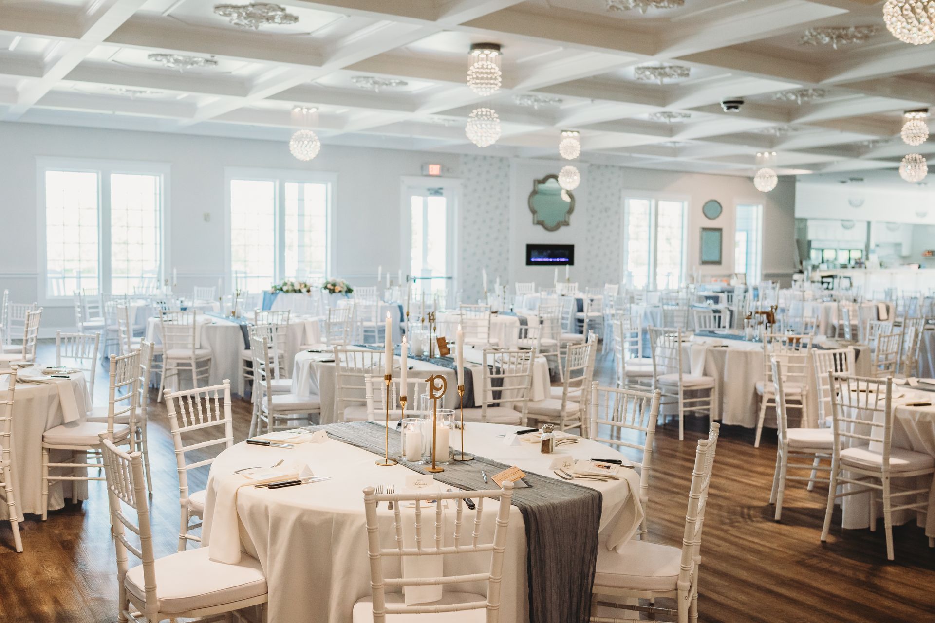 A large room with tables and chairs set up for a wedding reception.