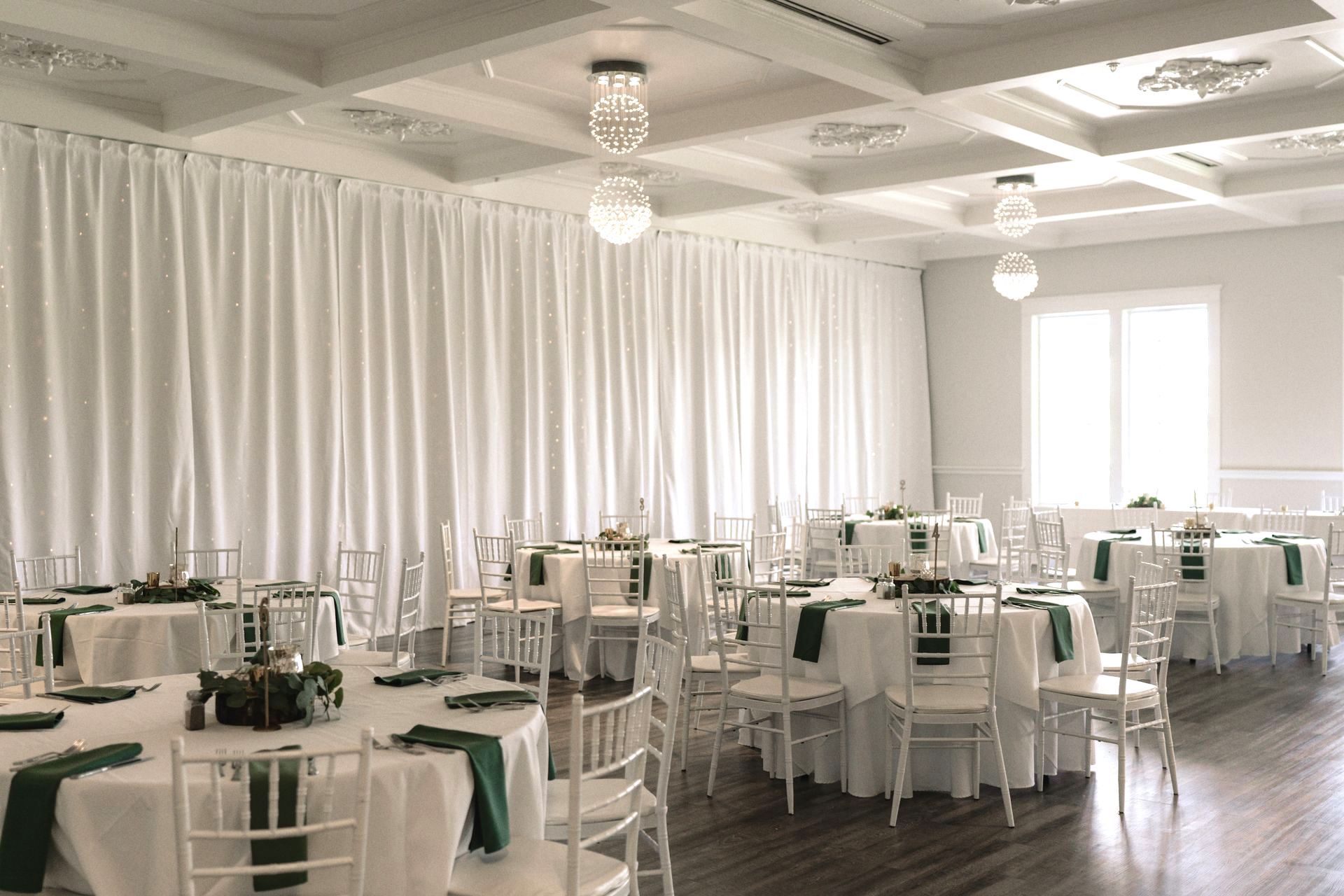 A large room with tables and chairs set up for a wedding reception.