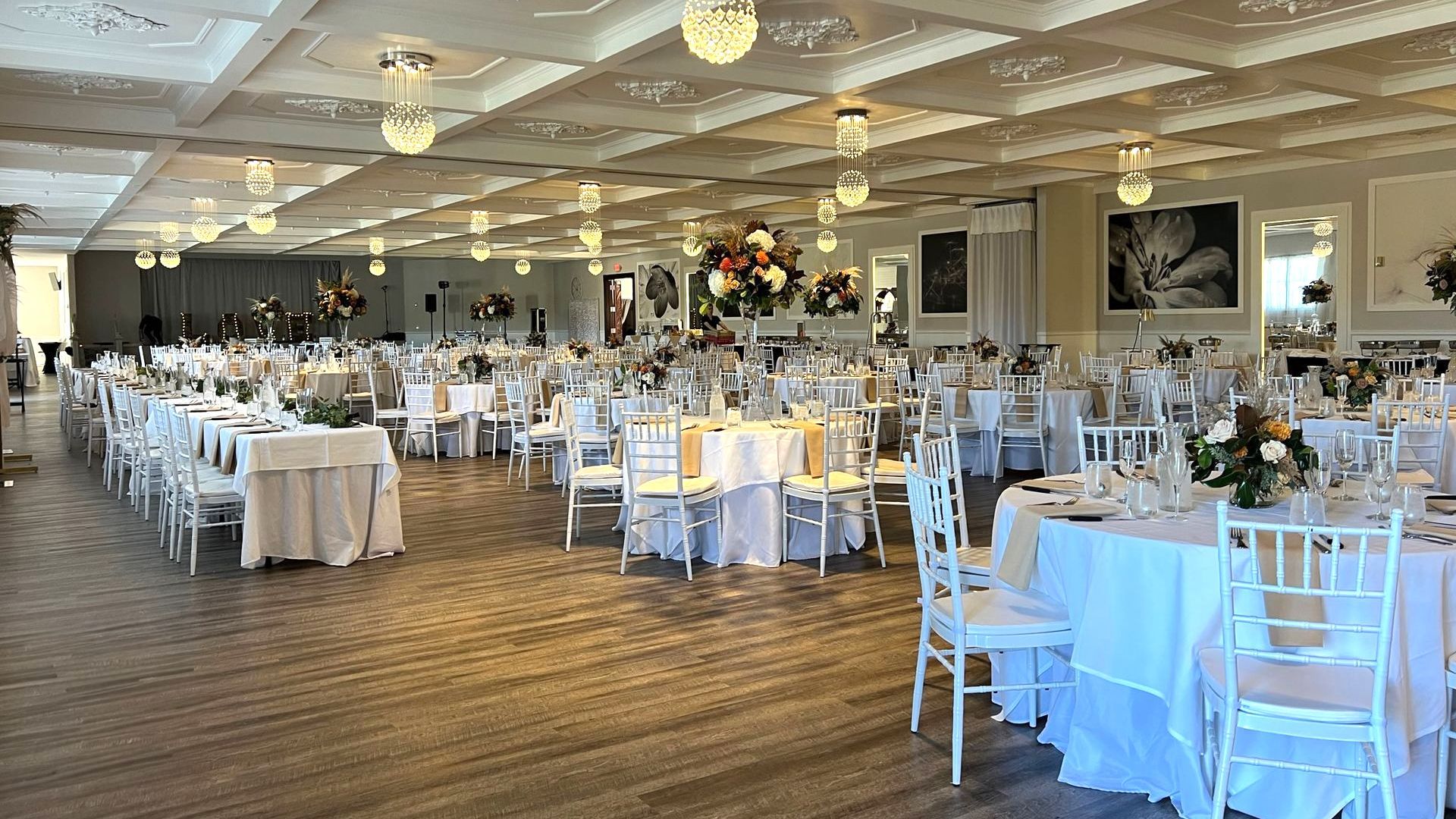 A large room with tables and chairs set up for a wedding reception.