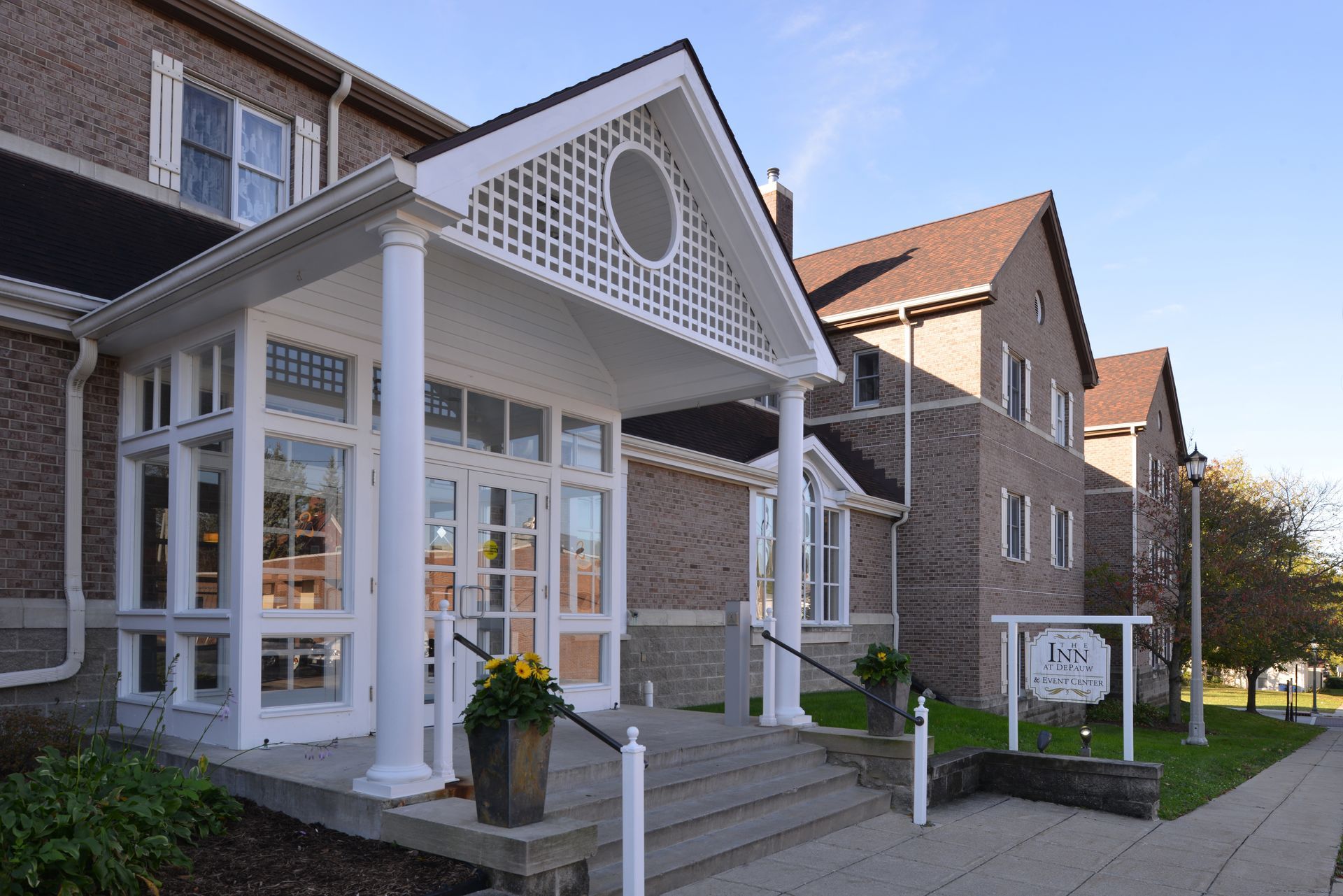 A large brick building with a white porch and stairs