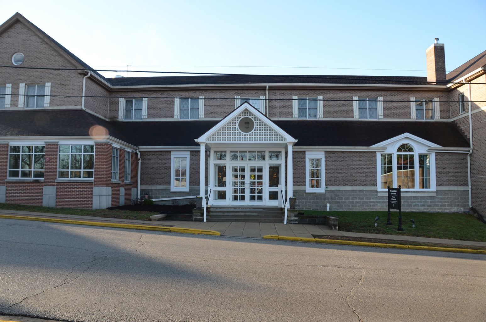 A large brick building with a black roof and white trim