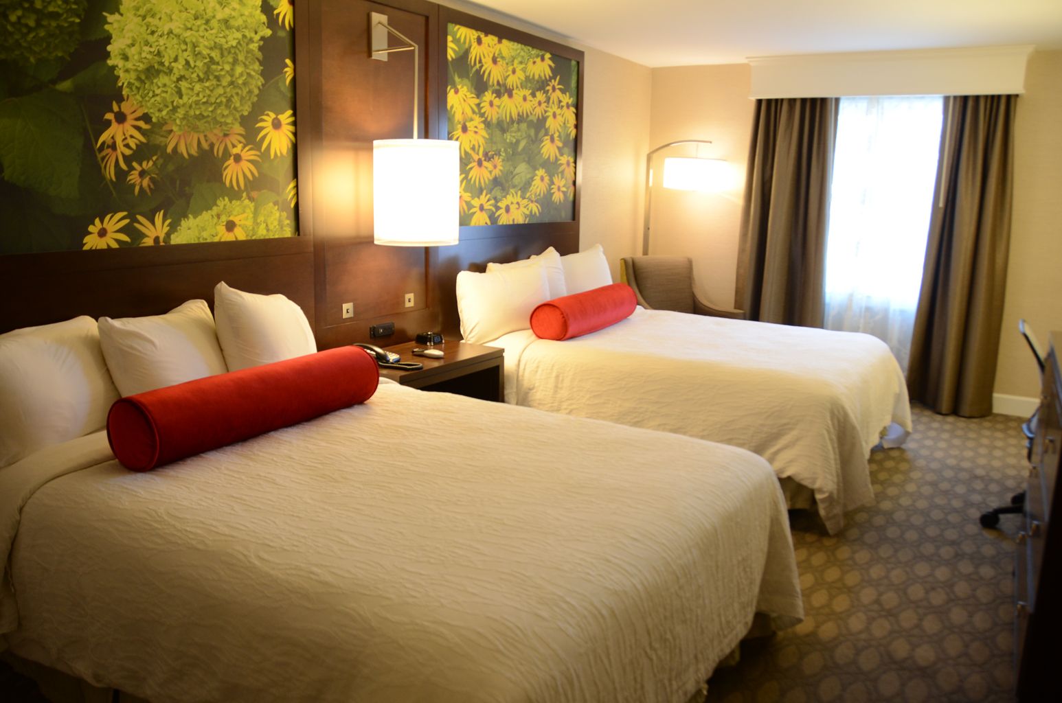 A hotel room with two beds and a window