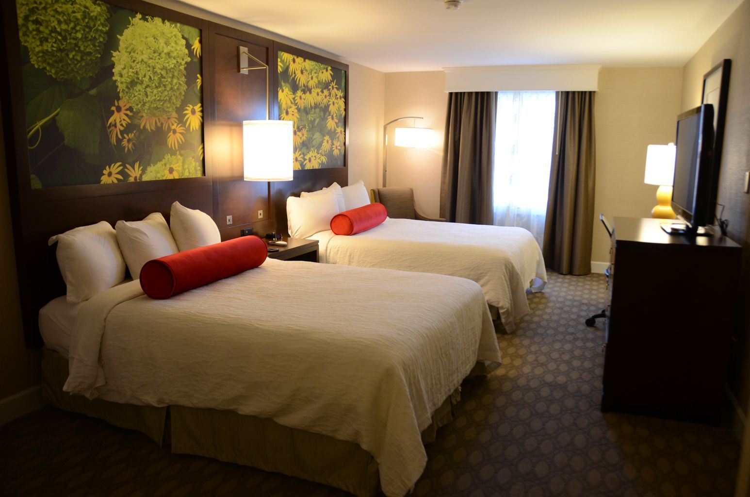 A hotel room with two beds and a television