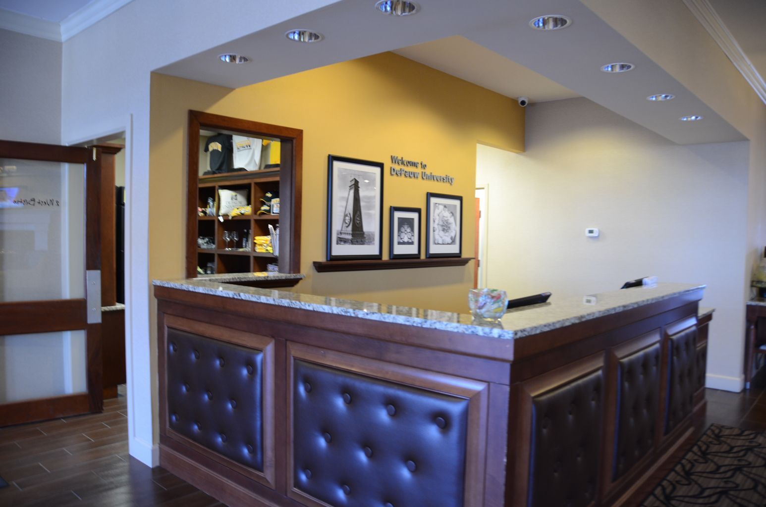 A hotel lobby with a large wooden reception desk
