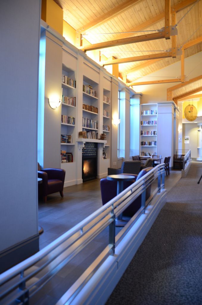 A long hallway with a railing and a fireplace