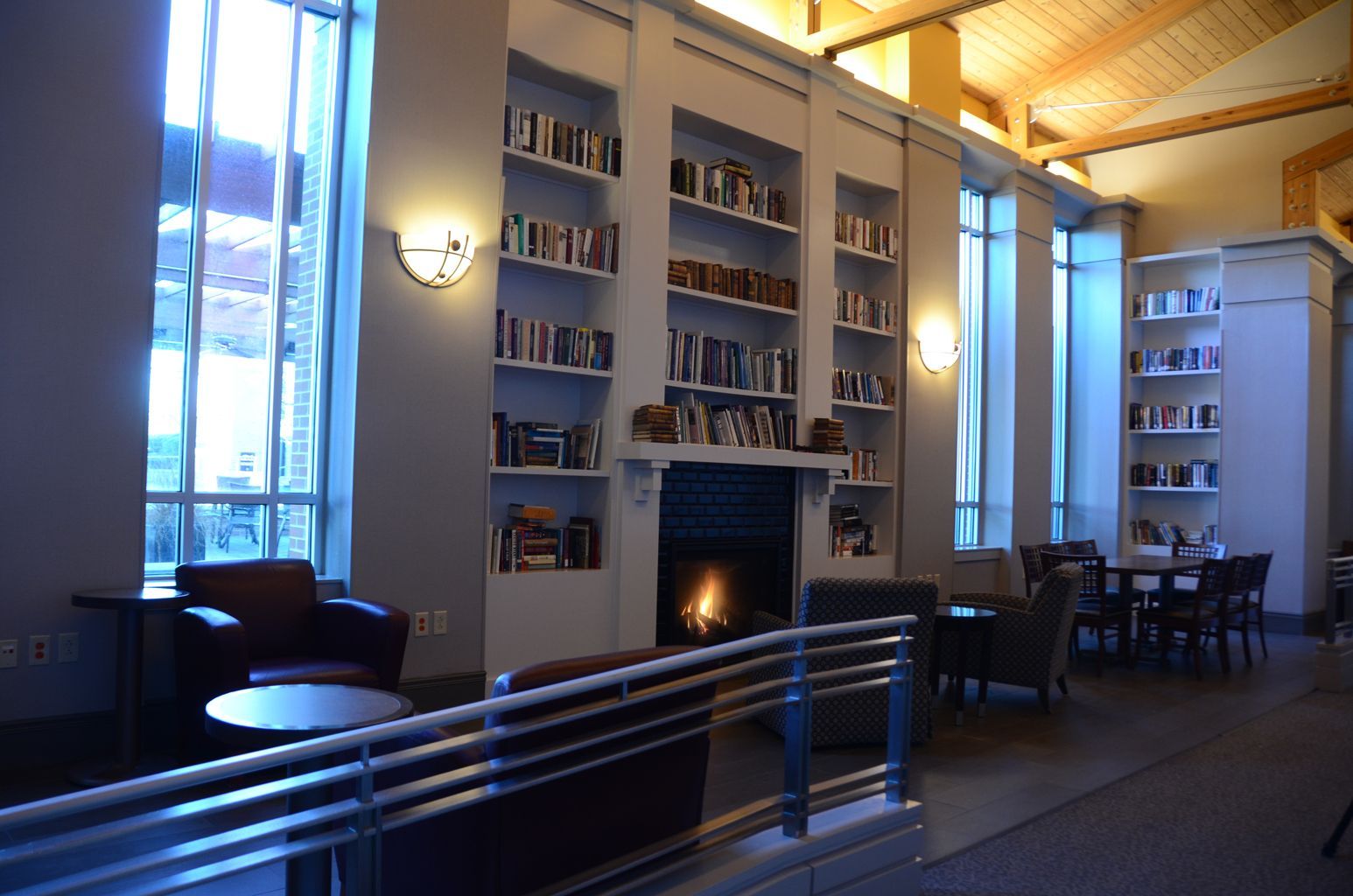 A library with a fireplace and shelves full of books