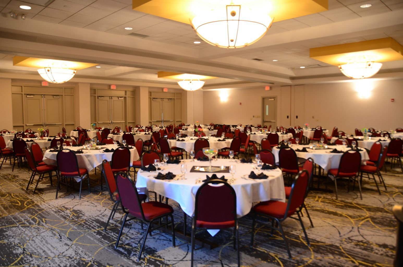 A large room with tables and chairs set up for a banquet.