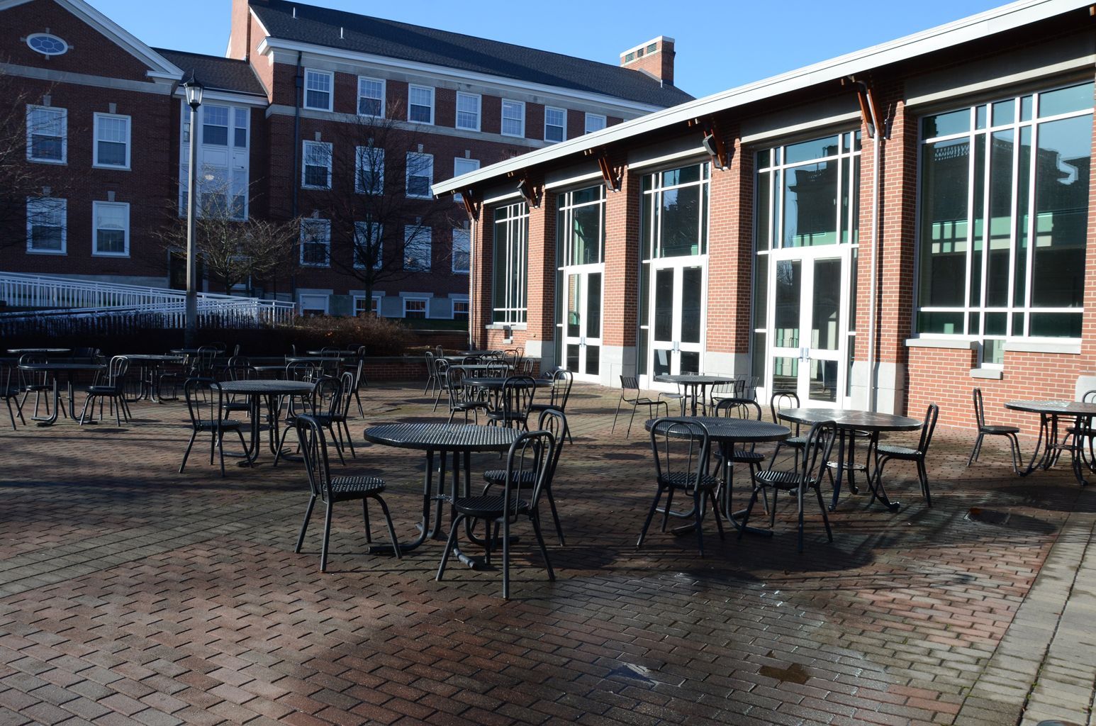 A brick building with tables and chairs in front of it