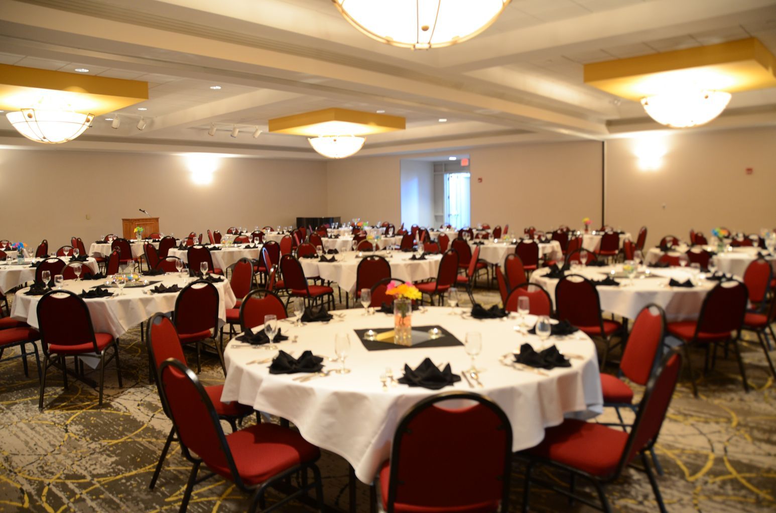 A large room with tables and chairs set up for a banquet.