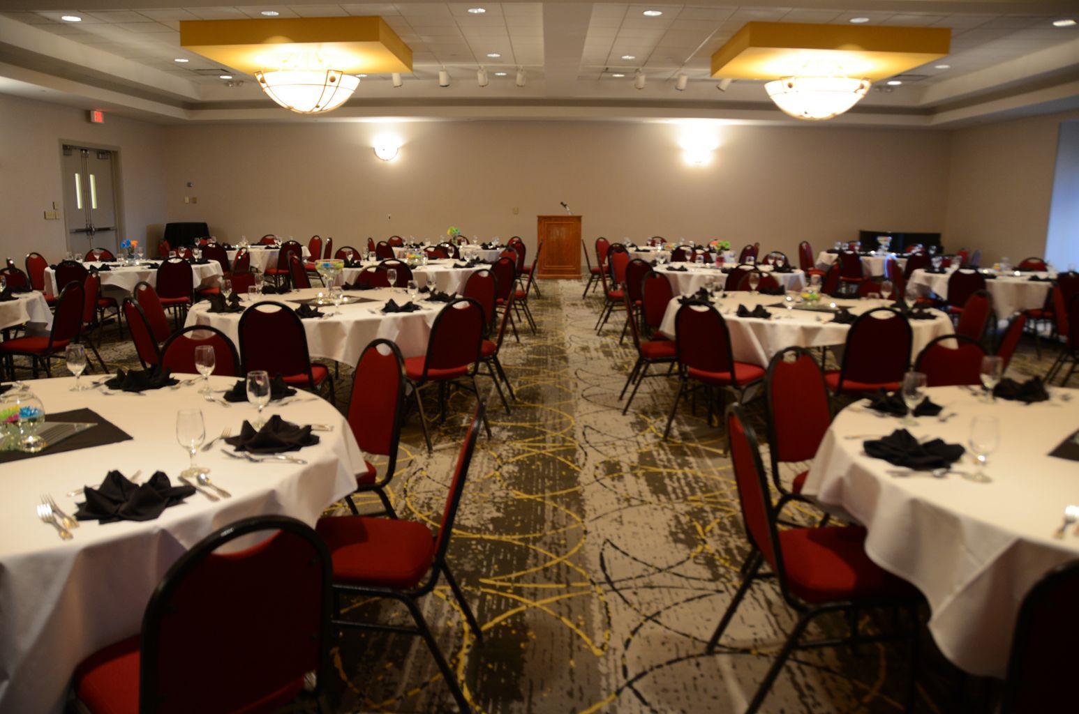 A large room with tables and chairs set up for a wedding reception.