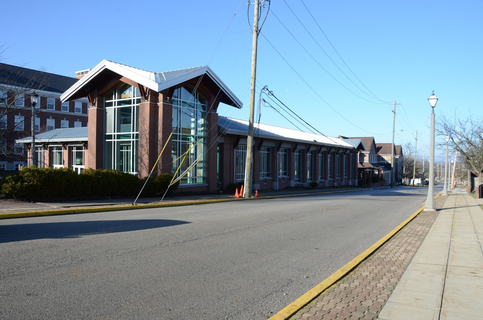 A building with a lot of windows is on the side of the road