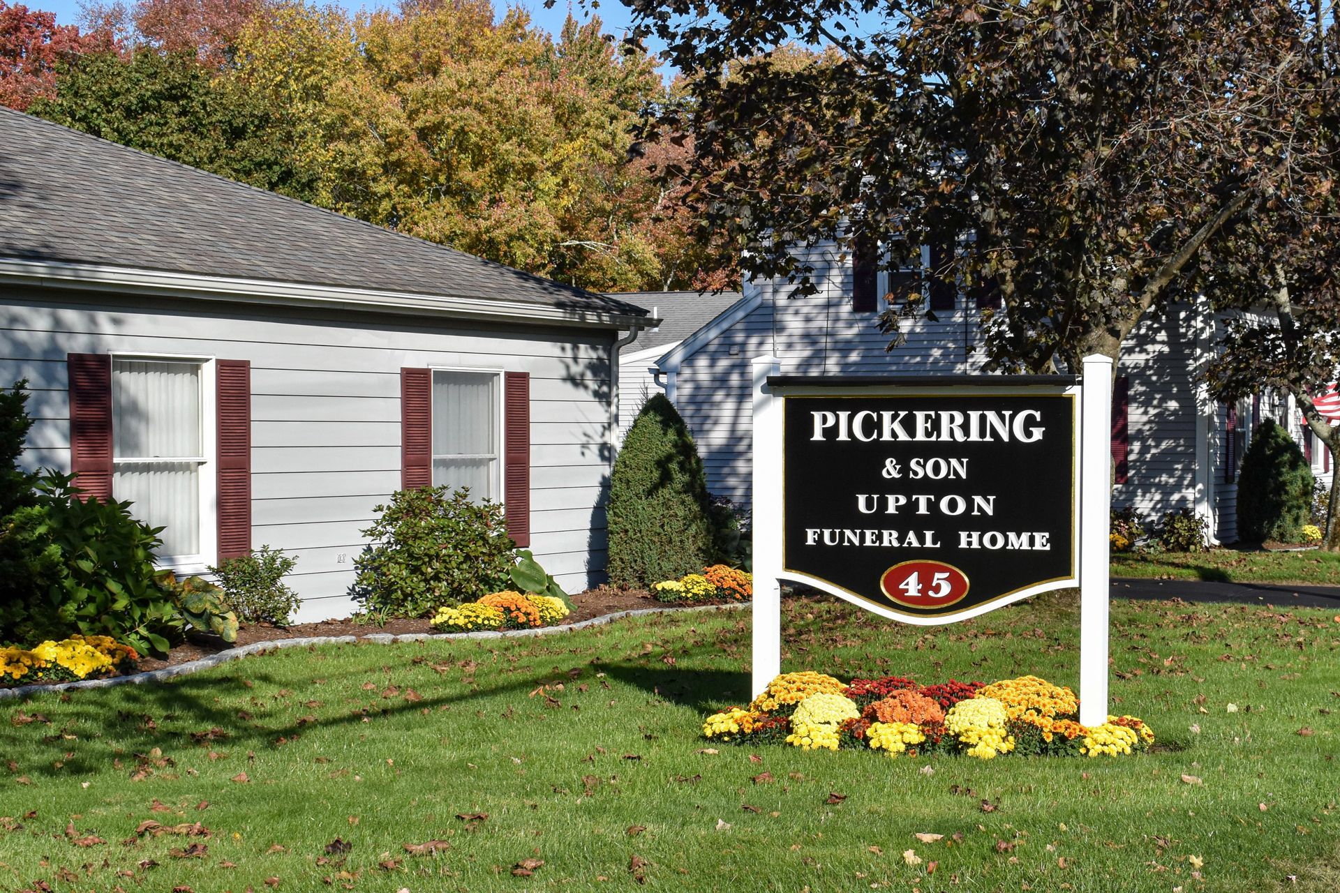 A sign in front of a house that says pickering & son upton funeral home
