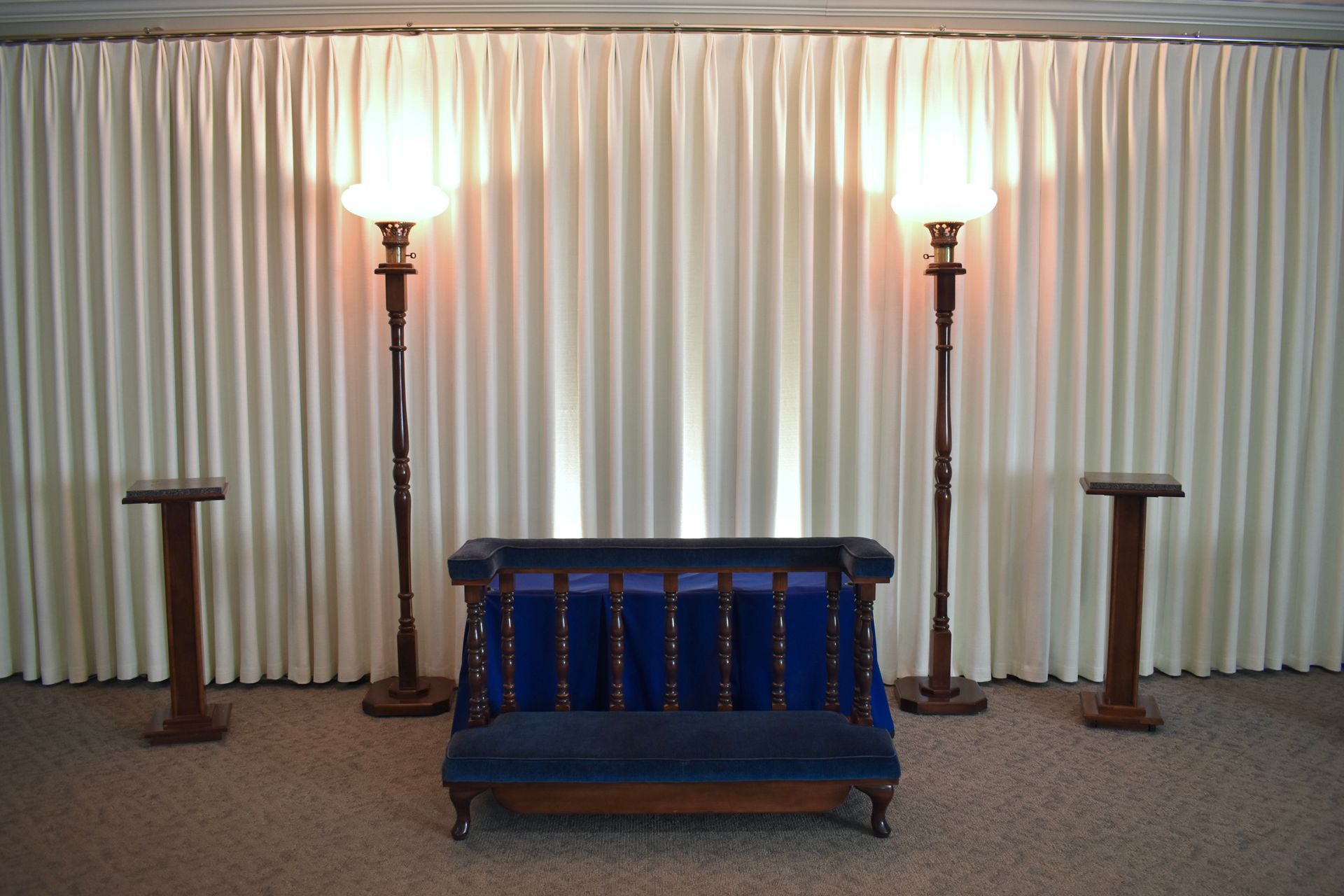 A room with a blue couch and two lamps
