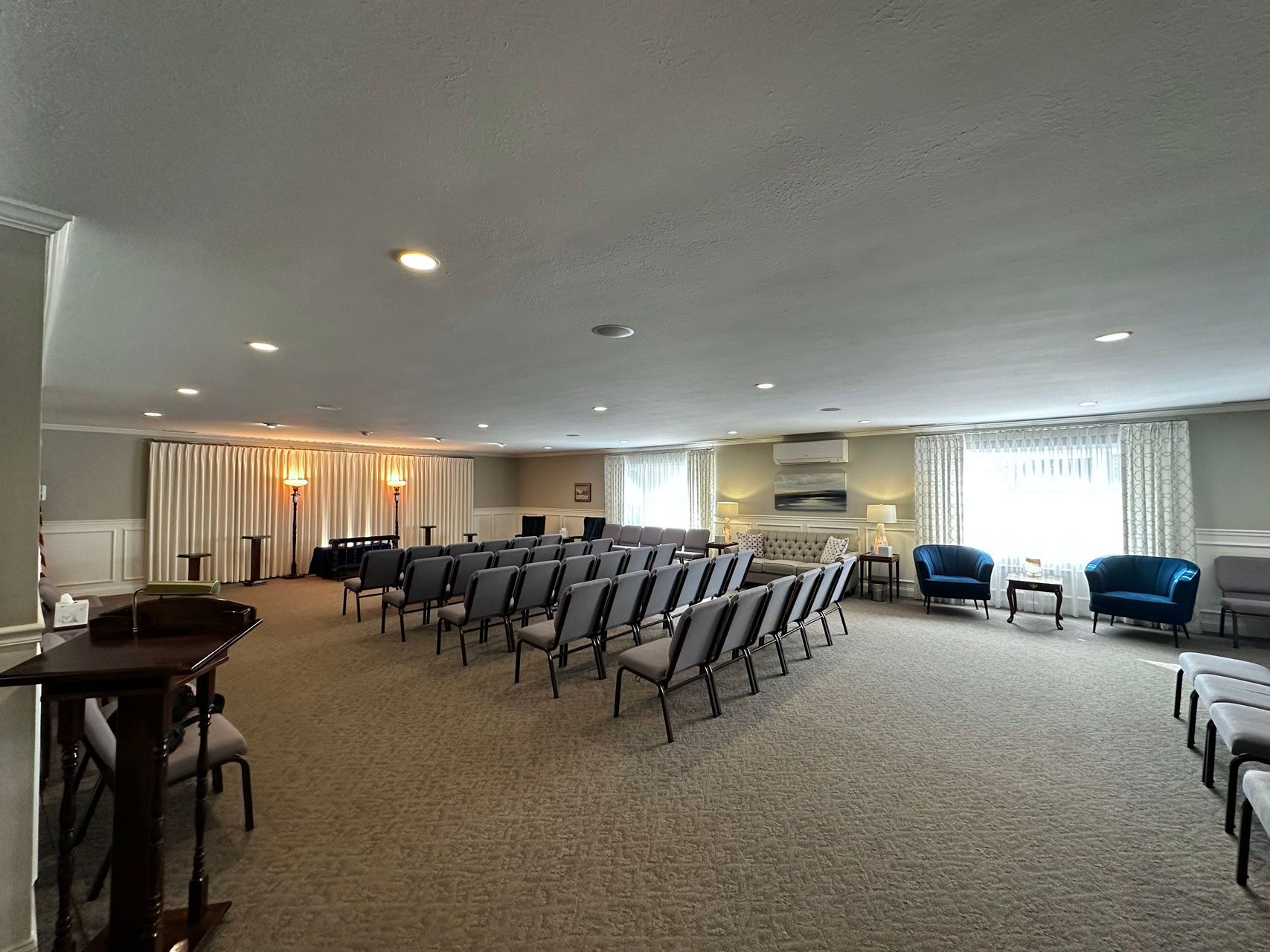A large room with rows of chairs and a piano.