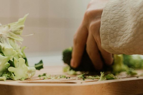 French Toast mit karamellisierten Äpfeln, Blaubeeren und Puderzucker auf einem dunklen Teller.