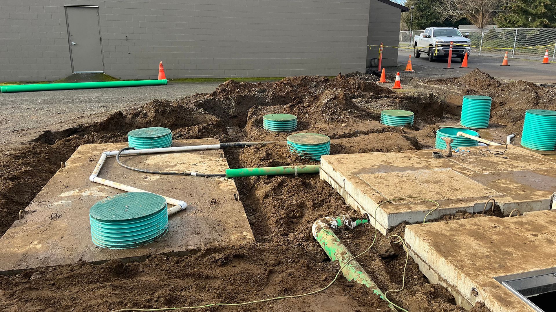 Construction site: Septic tank installation, with tanks, piping, and dirt.