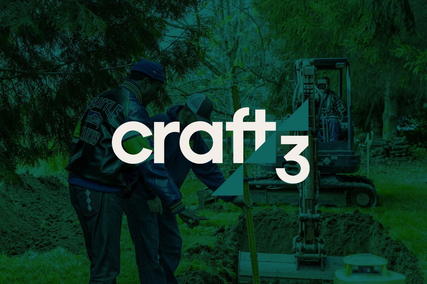Two men and an excavator in a grassy area. 