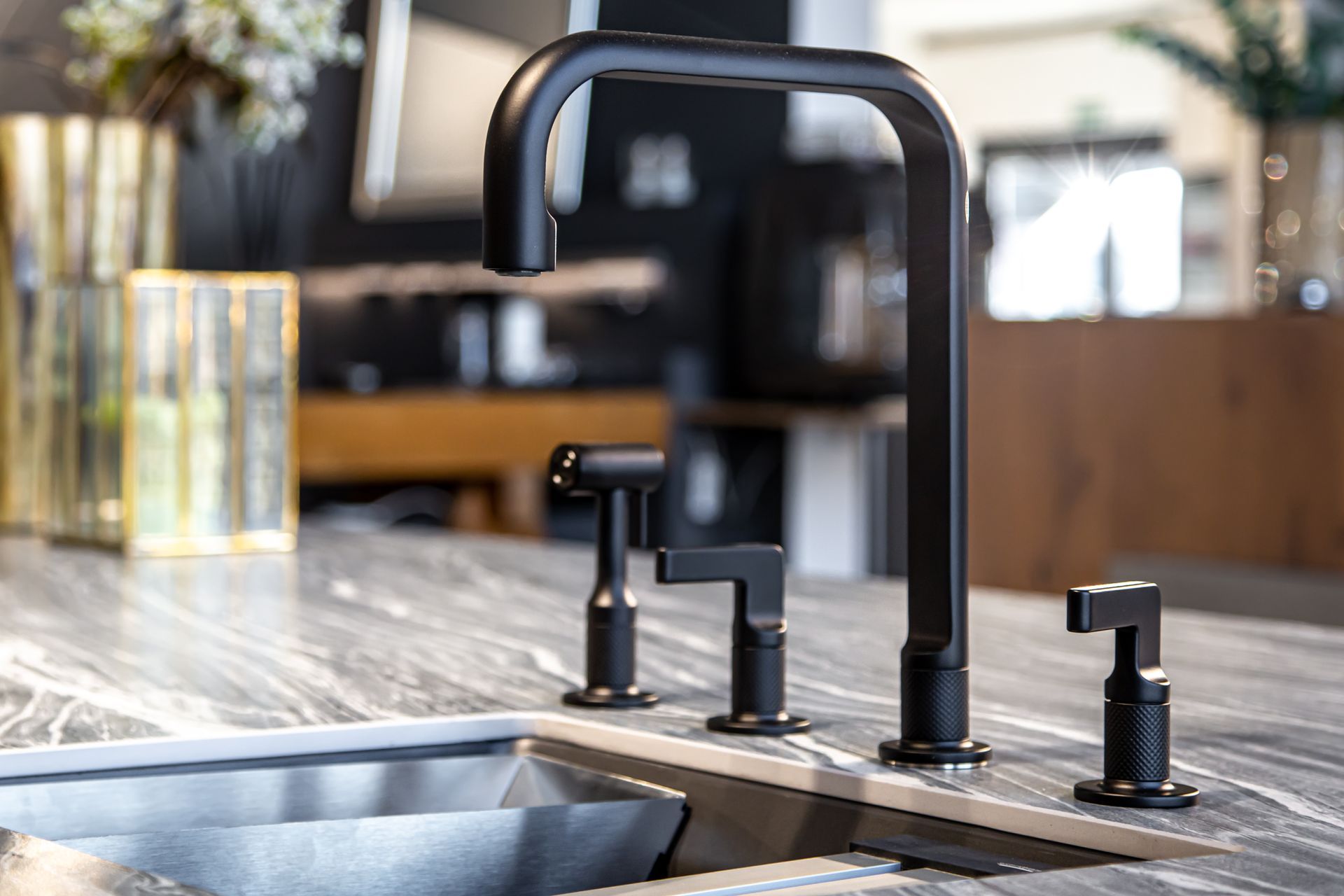A kitchen sink with a black faucet on a counter.