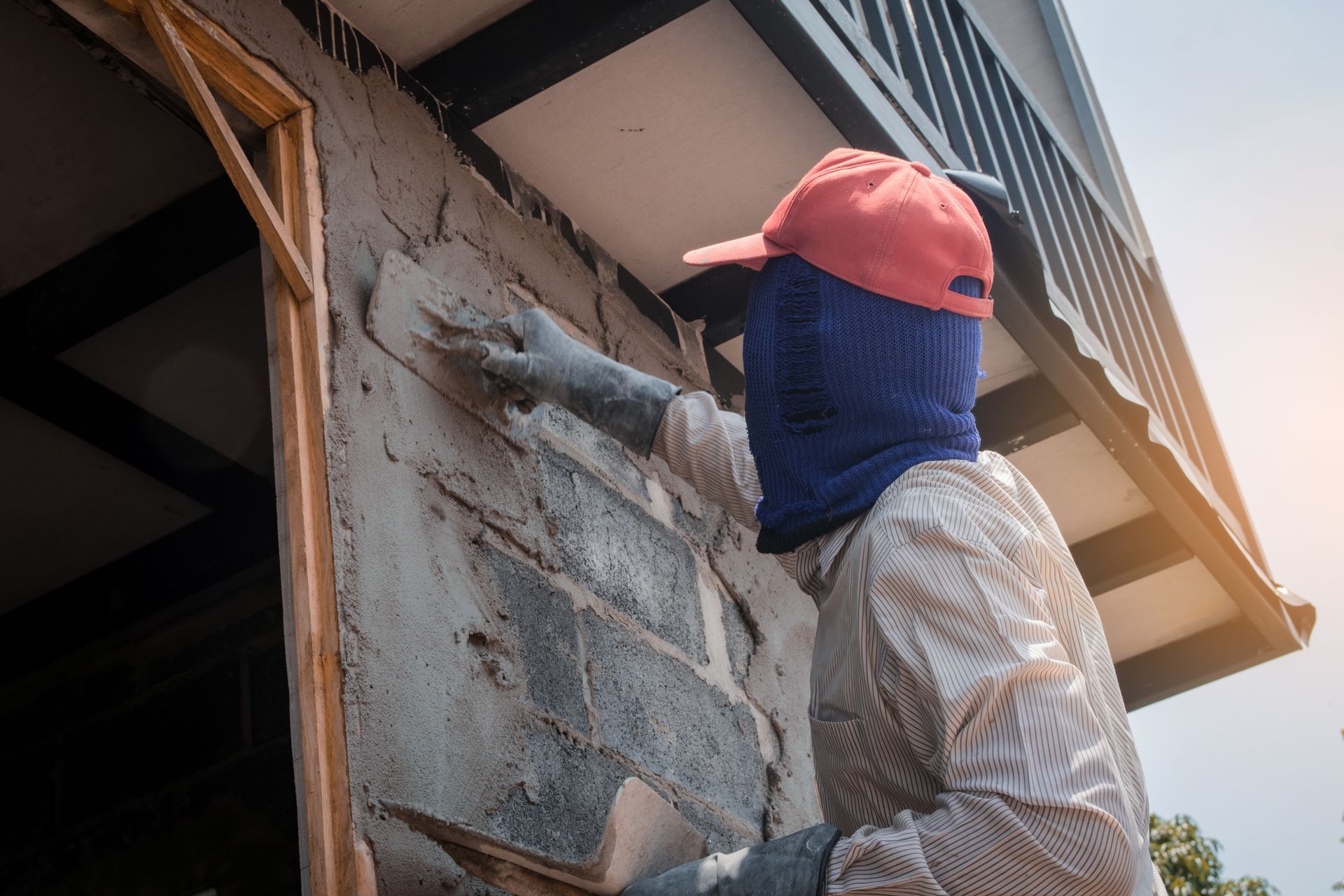 A man is plastering a wall with a trowel.
