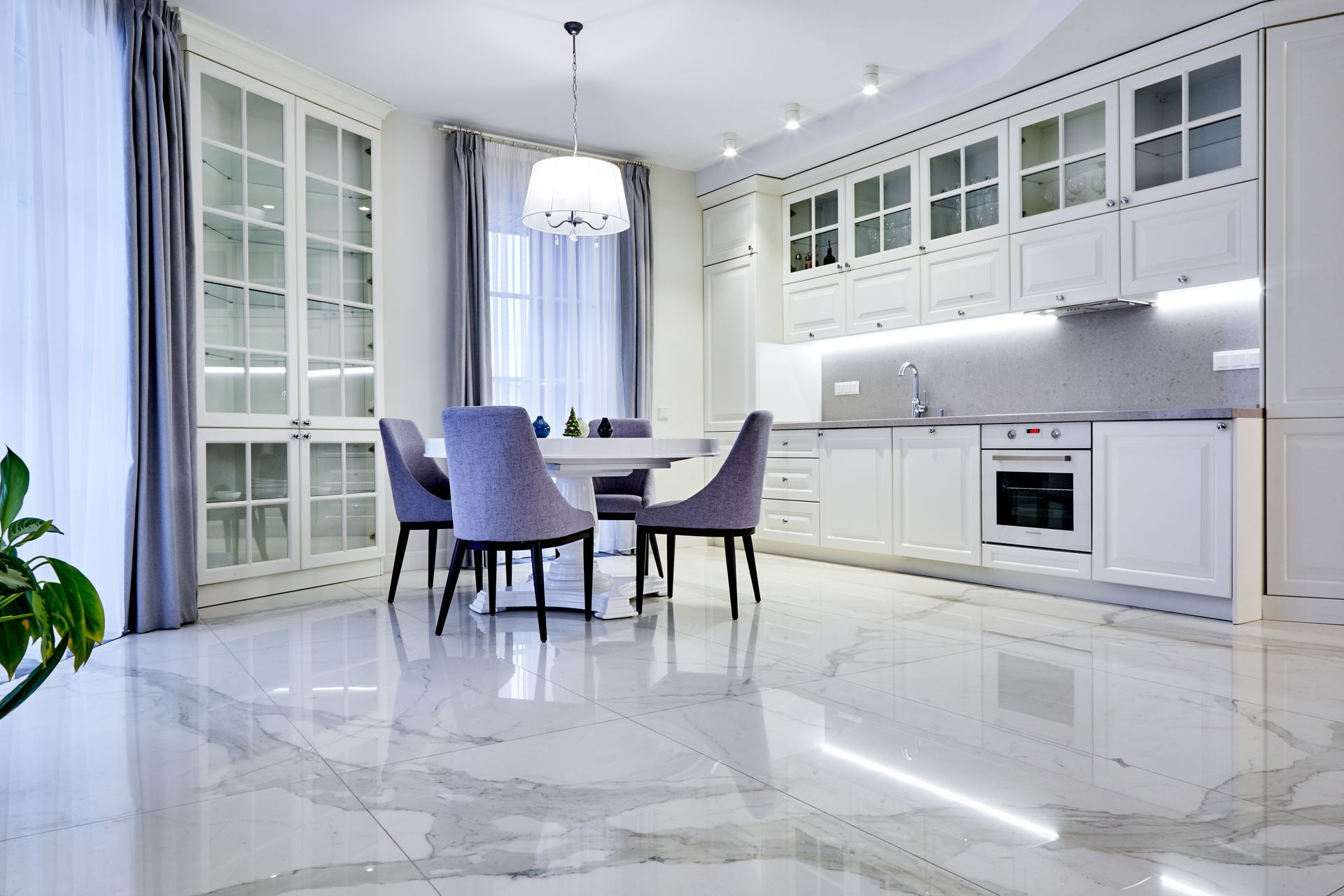 A kitchen with a table and chairs in it and a marble floor.