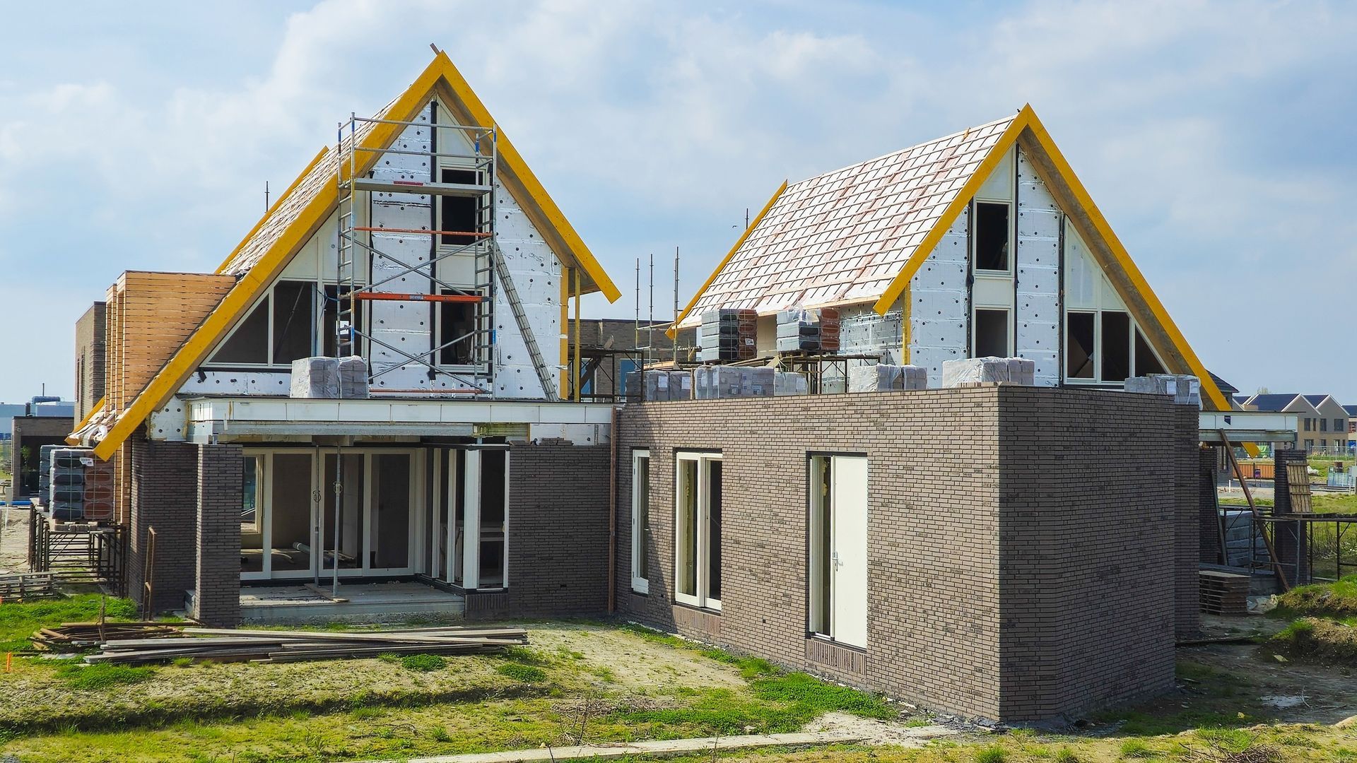 Two houses are being built in a residential area.