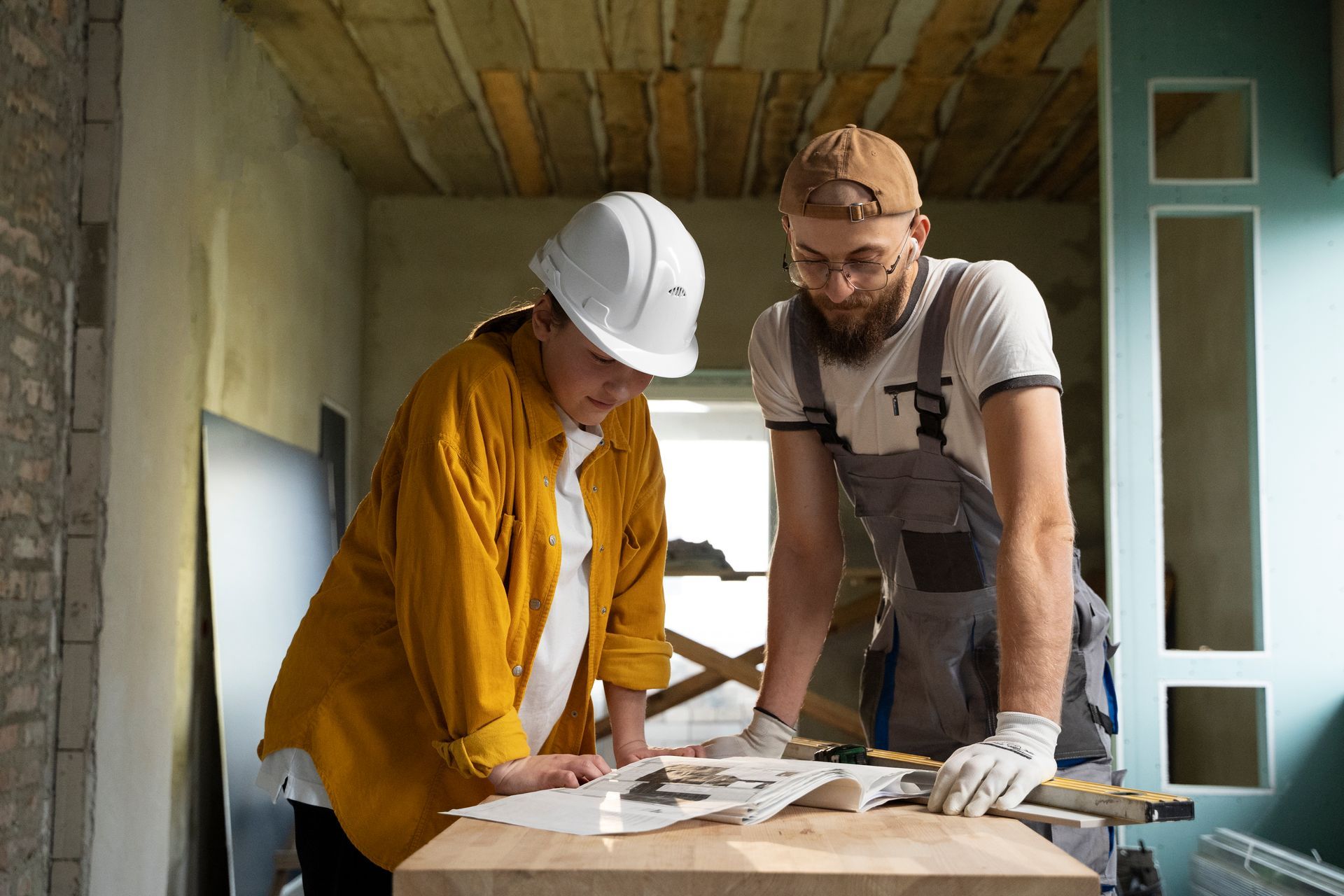 A man and a woman are working on a wooden table.