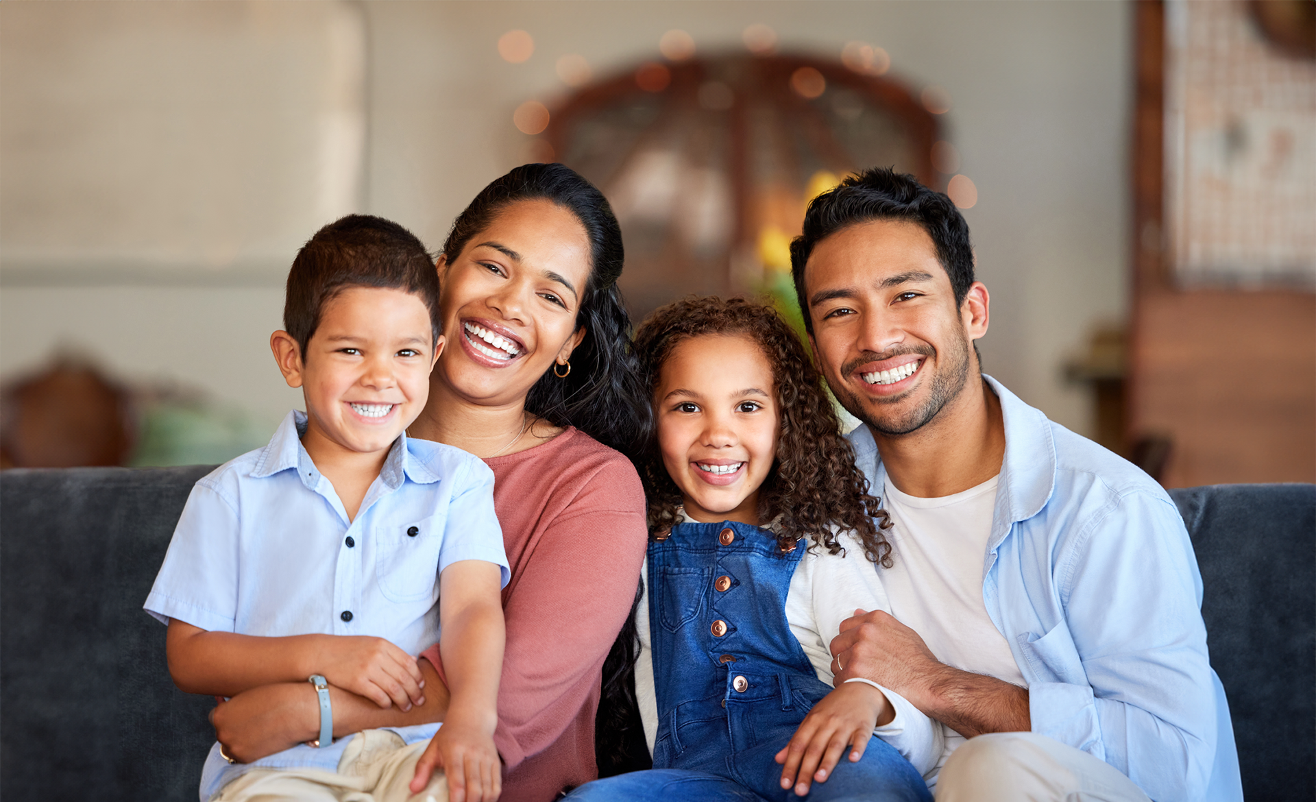 A family is sitting on a couch reading a book together.